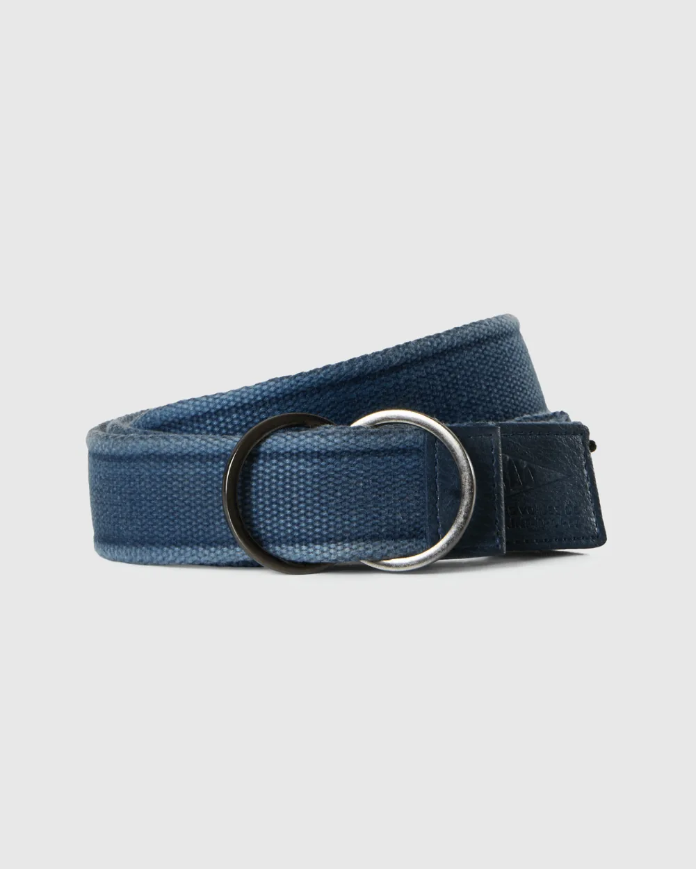 Ceinture Les Voiles 26 marine profond enroulée à plat : boucle à double anneau et patte d'extrémité frappée du logo Les Voiles de Saint-Tropez.