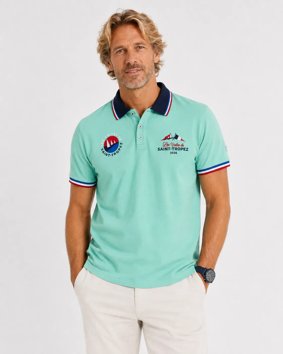 Polo Signature 26 vert menthe porté de face : col marine à galon tricolore, écusson rond à gauche, mention Les Voiles de Saint-Tropez 2026 à droite et écusson North Sails à la manche.
