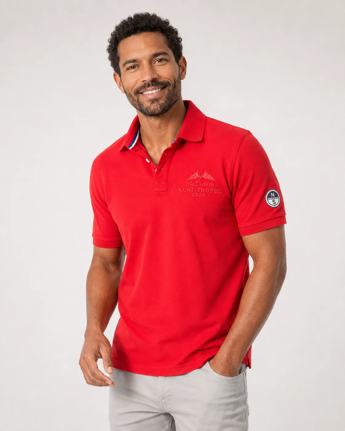 Polo Voiles 26 rouge samba porté de face : broderie ton sur ton sur la poitrine et écusson North Sails à la manche.